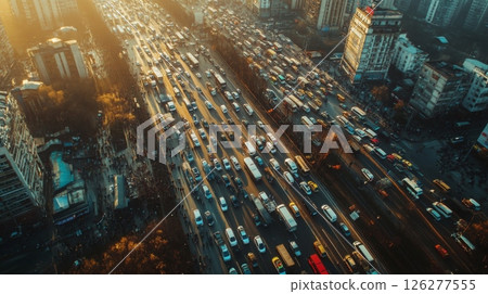Aerial view of a bustling city highway filled with a variety of vehicles during rush hour. The late afternoon sunlight casts a warm glow on the traffic, highlighting the busy atmosphere. 126277555