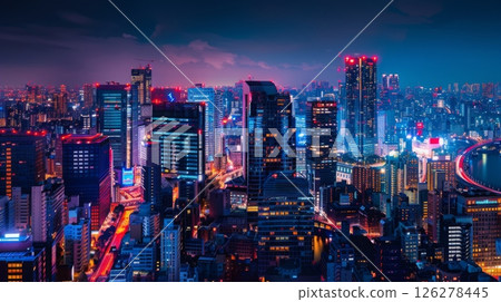 A night view of Tokyo's skyline, showing brightly lit skyscrapers and illuminated streets. A bridge stretches across a river in the distance. 126278445