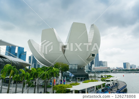 Singapore, Singapore - 4 April 2025: The iconic ArtScience Museum at Marina Bay Sands, with its lotus-inspired architecture, reflects on the water under cloudy skies. A must-see travel destination Singapore, Singapore - 4 April 2025: The iconic ArtScience Museum at Marina Bay Sands, with its lotus-inspired architecture, reflects on the water under cloudy skies. A must-see travel destination 126278808