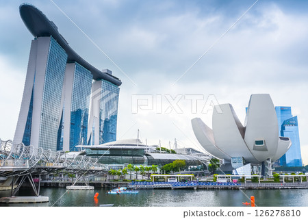 Singapore, Singapore - 4 April 2025: The iconic ArtScience Museum and Marina Bay Sands complex, connected by the pedestrian Helix Bridge, under moody cloudy skies. A panoramic view of Singapore's 126278810