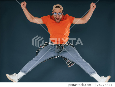 Jumping, feeling good, excited. Handsome man is in the studio against blue background Jumping, feeling good, excited. Handsome man is in the studio against blue background 126278845