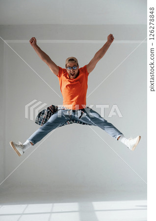 Happy guy is jumping, screaming and celebrating success. Handsome man is in the studio against white background 126278848