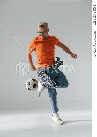 Doing tricks, playing with soccer ball. Handsome man is in the studio against white background Doing tricks, playing with soccer ball. Handsome man is in the studio against white background 126278851