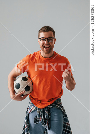 Active football fan is with soccer ball. Handsome man is in the studio against white background Active football fan is with soccer ball. Handsome man is in the studio against white background 126278865