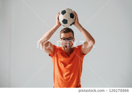 Active football fan is with soccer ball. Handsome man is in the studio against white background Active football fan is with soccer ball. Handsome man is in the studio against white background 126278866
