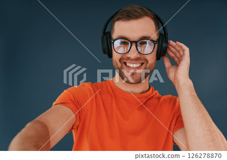 Handsome man is in the studio against blue background 126278870