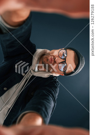 Handsome man is in the studio against blue background, Making selfie 126279188