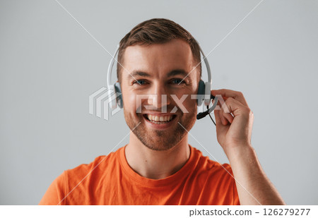 Conception of call center. In headset. Handsome man is in the studio against white background 126279277
