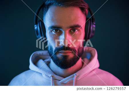 Beautiful portrait. In headphones. Handsome man is in the studio against background Beautiful portrait. In headphones. Handsome man is in the studio against background 126279357