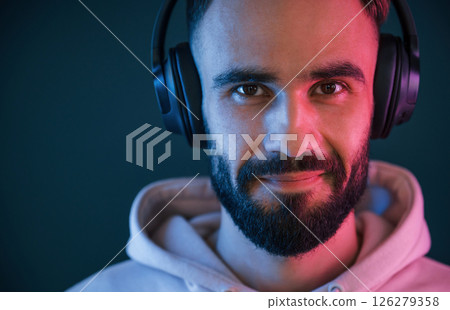 Beautiful portrait. In headphones. Handsome man is in the studio against background Beautiful portrait. In headphones. Handsome man is in the studio against background 126279358