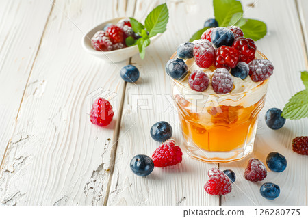 Glass of fruit juice with berries and whipped cream on top 126280775