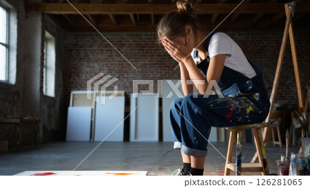 Artist Surrounded by Canvases, Holding Head in Hands 126281065