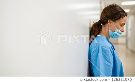Nurse Resting Head Against Hospital Wall After 12 Hour Shift 126281070