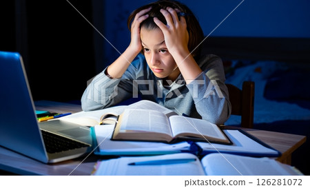 Teen Overwhelmed by Homework at Night Desk Setup 126281072