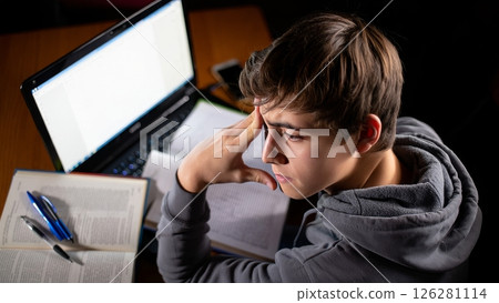 Teen Overwhelmed by Homework at Night Desk Setup 126281114
