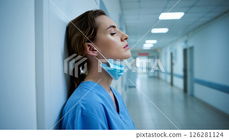 Nurse Resting Head Against Hospital Wall After 12 Hour Shift 126281124