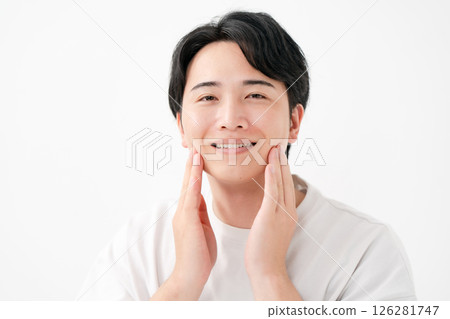 Smiling man touching his cheek 126281747