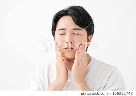 Smiling man touching his cheek 126281748