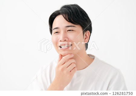 Smiling man touching his cheek 126281750