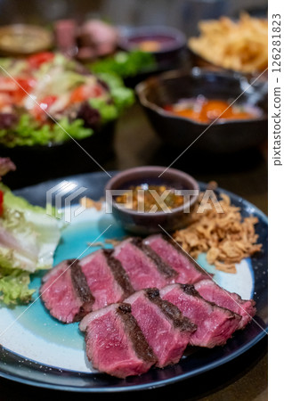 Medium rare sliced Picanha steak meat served on plate with vegetable Medium rare sliced Picanha steak meat served on plate with vegetable 126281823