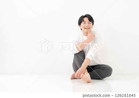 Young man, smiling, whole body, cross-legged Young man, smiling, whole body, cross-legged 126281845