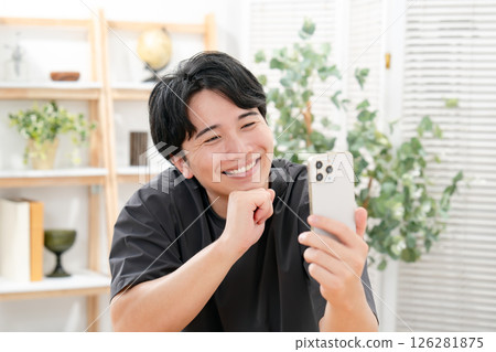 A man laughing at a smartphone 126281875