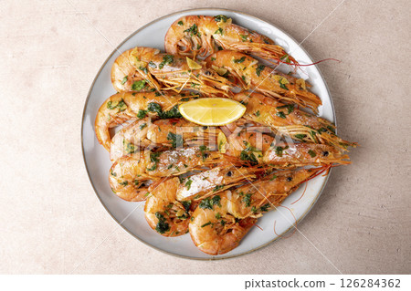 Langoustines fried in butter with garlic and parsley. Served with a slice of lemon. Traditional Mediterranean cuisine. A popular appetizer in restaurants and pubs. Homemade cooking. Selective focus. Langoustines fried in butter with garlic and parsley. Served with a slice of lemon. Traditional Mediterranean cuisine. A popular appetizer in restaurants and pubs. Homemade cooking. Selective focus. 126284362