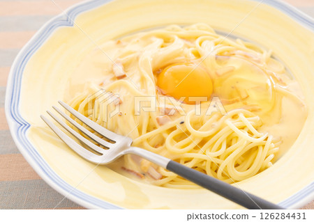Delicious carbonara pasta topped with raw egg Delicious carbonara pasta topped with raw egg 126284431