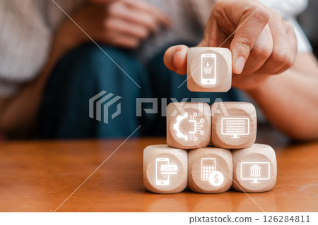 Wooden blocks with e-payment icons representing digital transactions and financial technology in a modern setting. 126284811