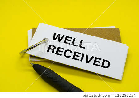 Well Received Text on white notepad with yellow cover background 126285234