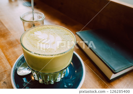 Reading with a matcha latte at a cafe Reading with a matcha latte at a cafe 126285400