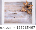 A frame of dried flowers placed on a wooden board 126285467