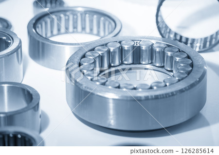 Close up scene assembly of the cylindrical rolling bearing parts in the light blue scene. Close up scene assembly of the cylindrical rolling bearing parts in the light blue scene. 126285614