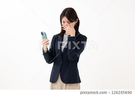 一個女人驚訝地看到一部智能手機 126285690