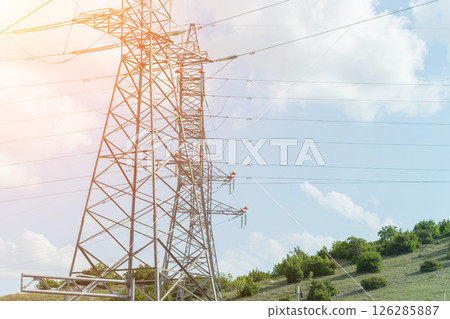 High voltage towers with sky background. Power line support with wires for electricity transmission. High voltage grid tower with wire cable at distribution station. Energy industry, energy saving 126285887