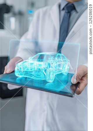 Auto engineer next to a holographic model of a car. Innovative technologies in the development of car design. A glimpse of the future as the engineer studies the holographic car. 126286019