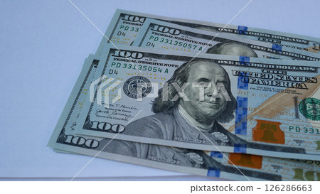 The hand puts hundred-dollar bills on the table, counts money. 126286663