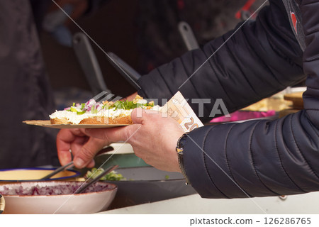 Person Buying a Sandwich at a Food Market Stand Person Buying a Sandwich at a Food Market Stand 126286765
