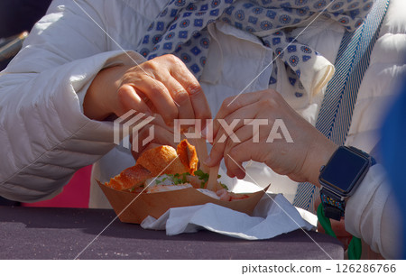 Close-Up of Hands Sharing a Meal in a Casual Setting 126286766