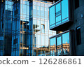 Contemporary Urban Architecture featuring Glass building Facades with reflections surrounding structures. Juxtaposition sleek modern design classic elements, cityscape elegance and structural details 126286861