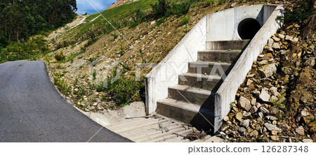 Large concrete pipe for drainage in the rocky regions of Portugal. Concept for drainage works, water treatment, slope stabilization in building construction Large concrete pipe for drainage in the rocky regions of Portugal. Concept for drainage works, water treatment, slope stabilization in building construction 126287348