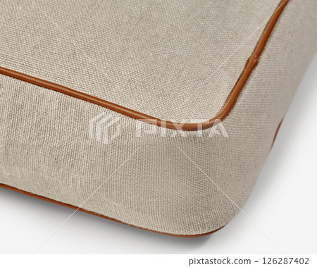 Corner of beige linen fabric with brown leather piping detailing showing skilled craftsmanship Corner of beige linen fabric with brown leather piping detailing showing skilled craftsmanship 126287402