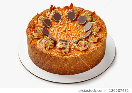 Delicious round pumpkin cheesecake decorated with chocolate and caramel topping 126287481