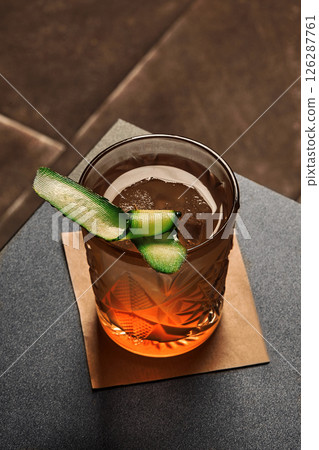 Crystal cocktail glass with cucumber garnish on bar top 126287761