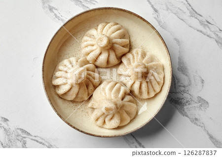 Khinkali dumplings sprinkled with black pepper resting in bowl Khinkali dumplings sprinkled with black pepper resting in bowl 126287837