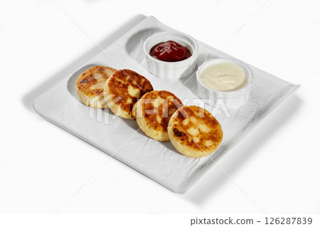 Syrniki with jam and sour cream served on white plate Syrniki with jam and sour cream served on white plate 126287839