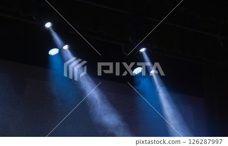 Spotlights shine brightly, producing visible beams of light 126287997