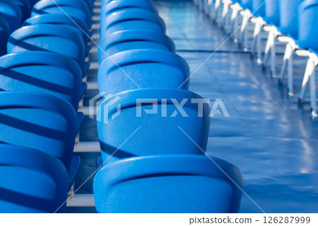 An arrangement of bright blue stadium seats, closeup abstract photo An arrangement of bright blue stadium seats, closeup abstract photo 126287999