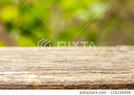 Wooden surface in focus with blurred green outdoor background for nature concepts 126288406