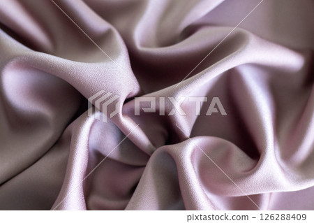 Close-up of soft pink fabric with gentle folds and smooth texture 126288409